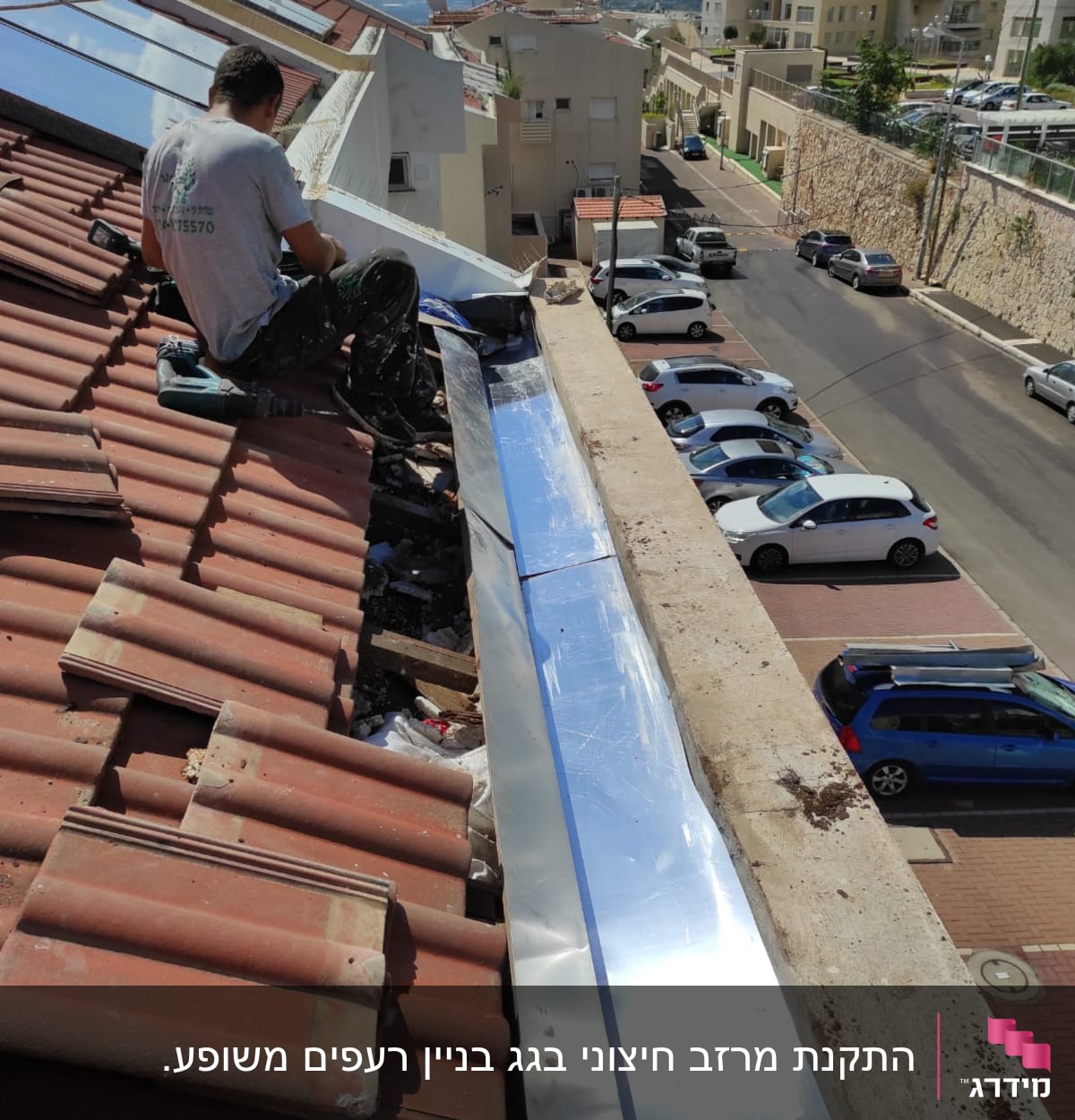 אדם עובד על גג רעפים עם יריעת מתכת